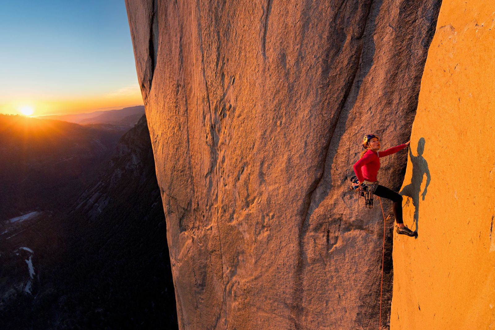 An individual engaged in outdoor rock climbing during a sunny day.