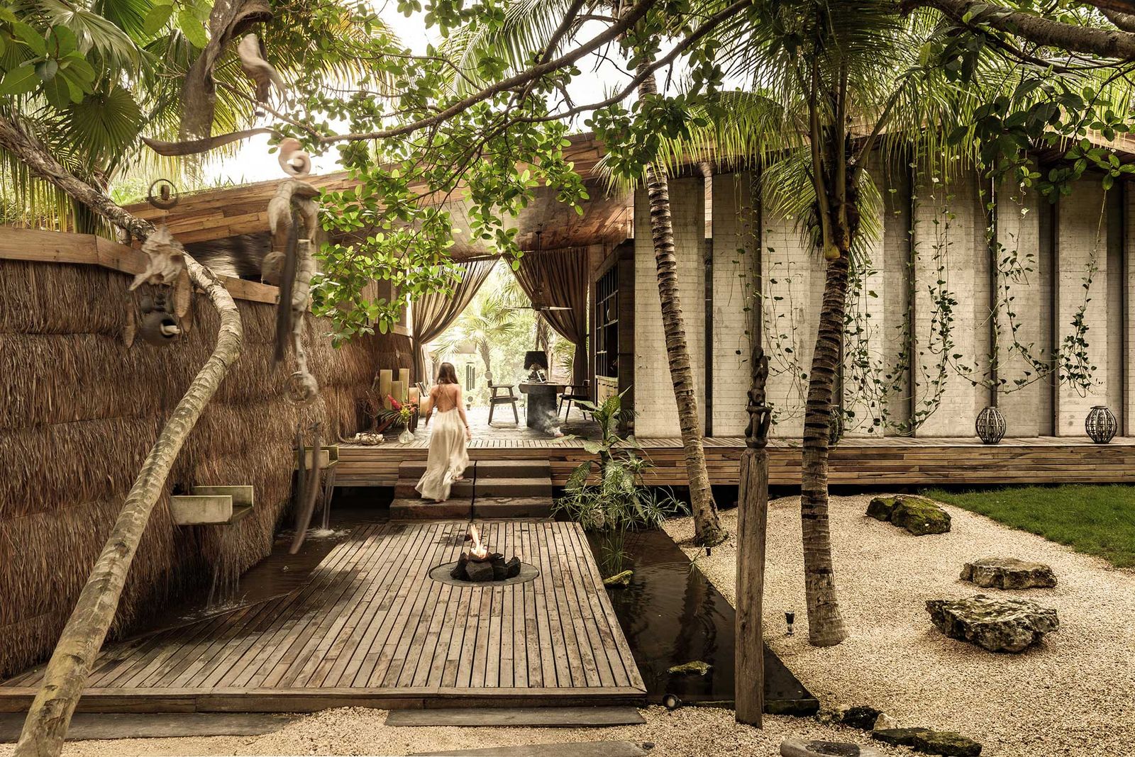 A luxurious resort chair under a tree within a green, lush garden setting.