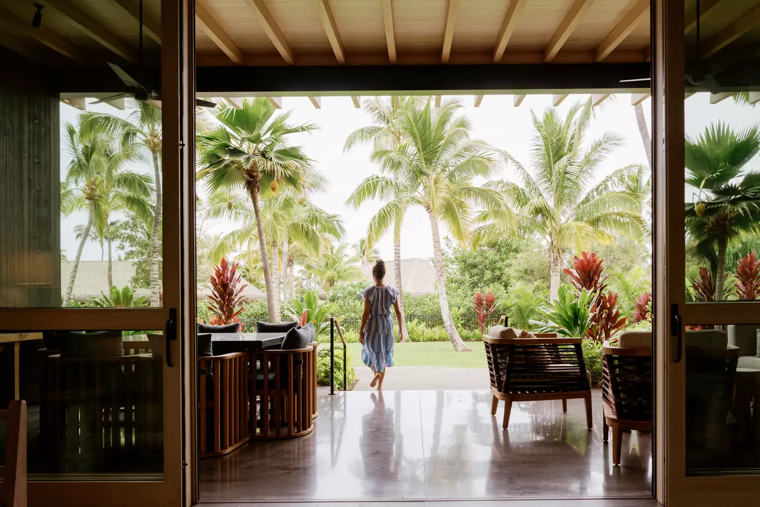 A terrace at the Kona Village, Rosewood, resort in Hawaii featuring wooden flooring and tropical views.