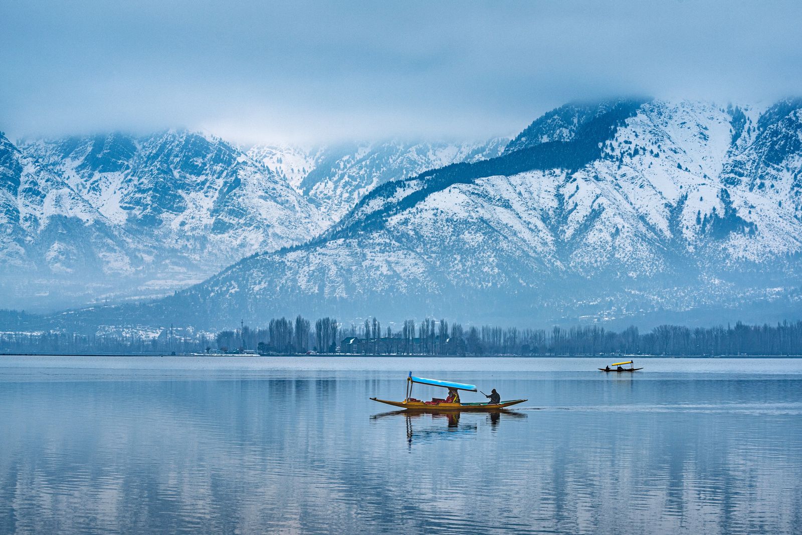 A person rowing a small boat through calm waters, typical of Kerala's backwaters.