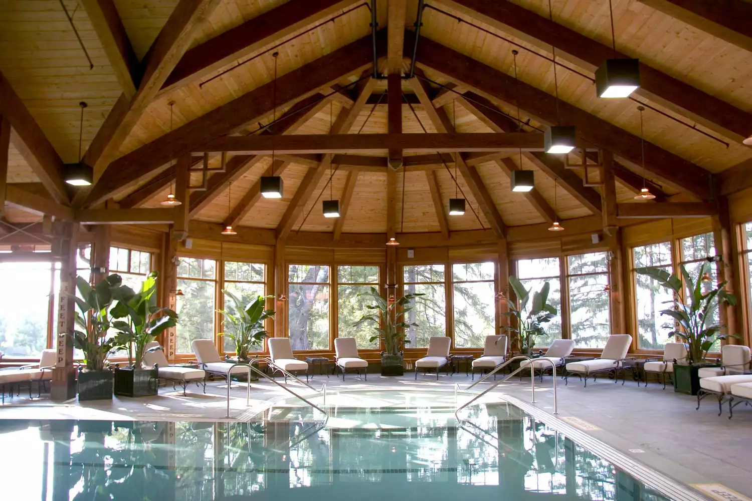 The grand indoor heated swimming pool at Mohonk Mountain House with high ceilings and large windows.