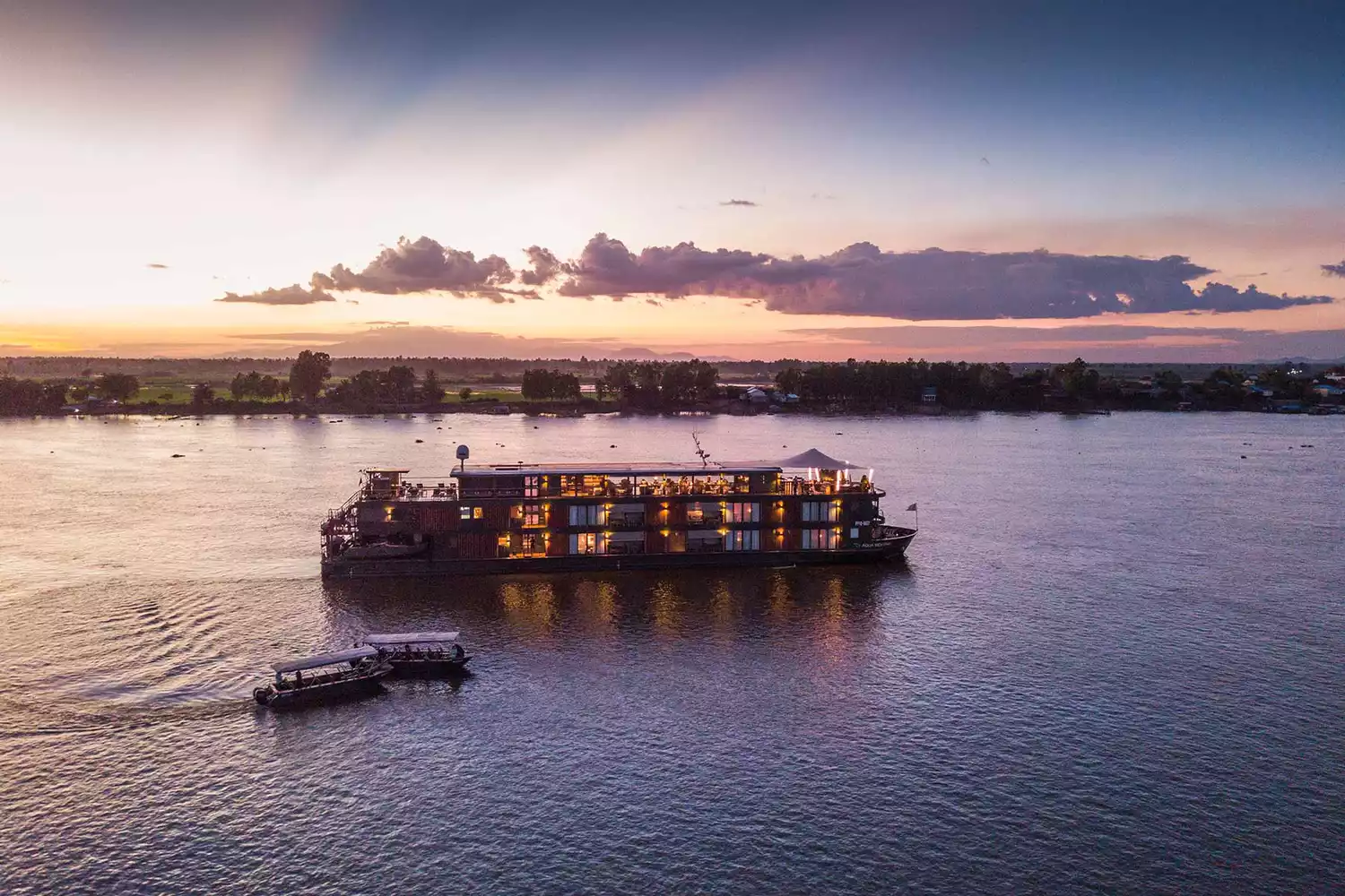 The Aqua Mekong river vessel sailing through a lush tropical landscape.