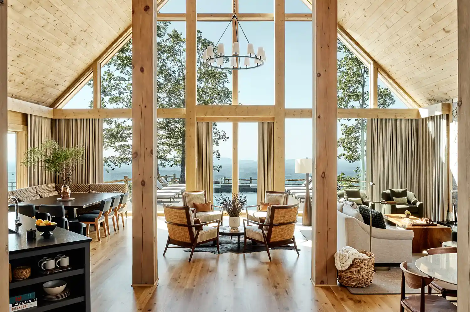 Modern luxury cabin interior with tall windows and a scenic mountain view.