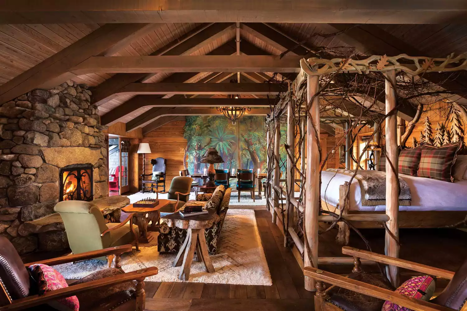The rustic wood-beamed interior of Lake Placid Lodge with a view towards the lake.