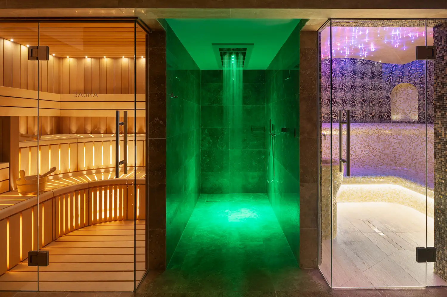 Interior view of the Ayan Spa pool area with atmospheric green lighting and sauna facilities.