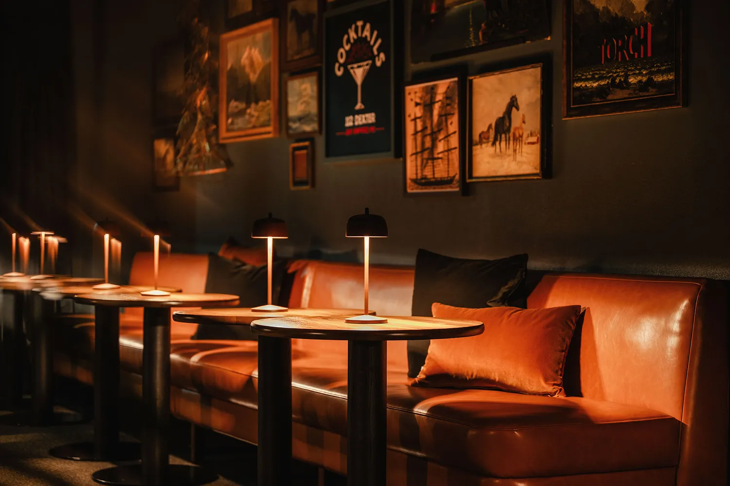 Interior of Noble Lounge featuring leather sofas and framed wall art.