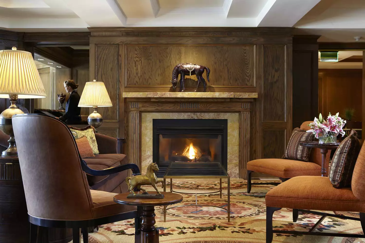 The Lincoln Room at the American Club featuring a grand fireplace and classic wood-paneled walls.