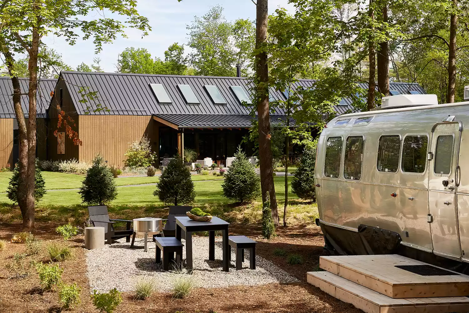 A silver Airstream trailer parked at AutoCamp Catskills with a private deck.