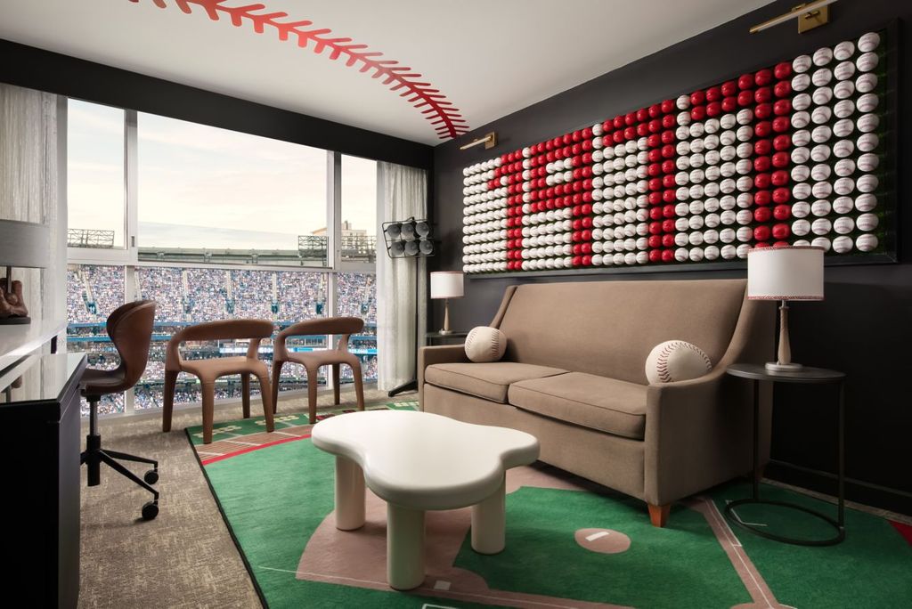 A hotel suite interior with large windows providing a full view of the Rogers Centre baseball field.