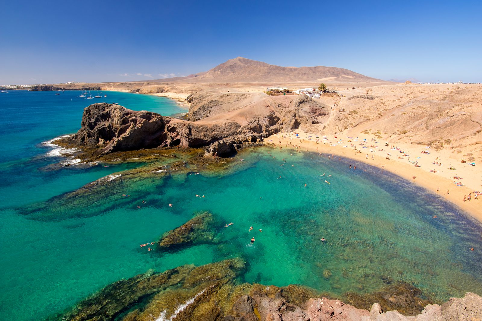 Natural rock pools formed on a shoreline overlooking a wide bay.