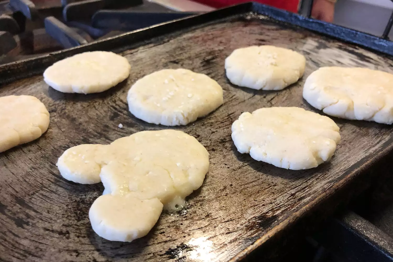 A family participating in an arepa-making class with a guide.