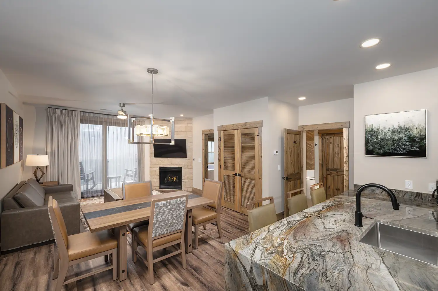 Modern open-concept living room and kitchen with mountain-themed wooden decor.