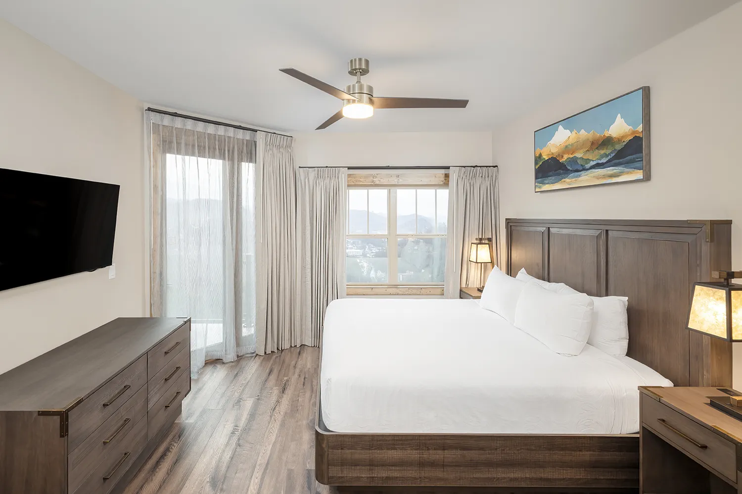 Interior of a luxury villa bedroom with dark wood furniture and premium bedding.