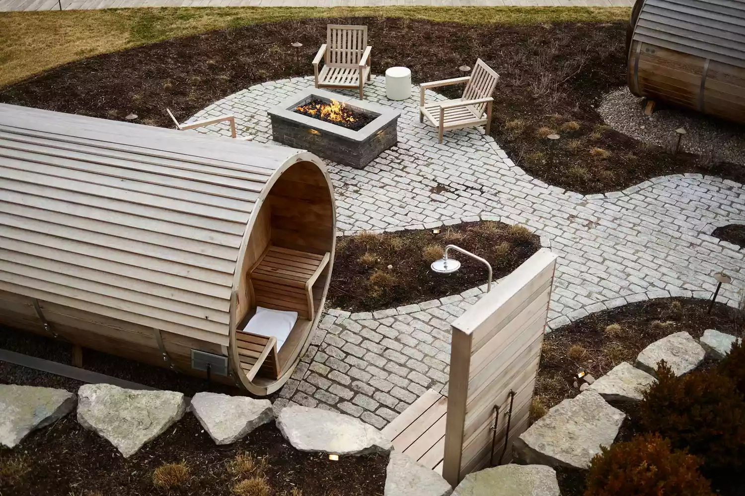 Aerial view of a circular wooden sauna and fire pit area at The Lake House on Canandaigua.