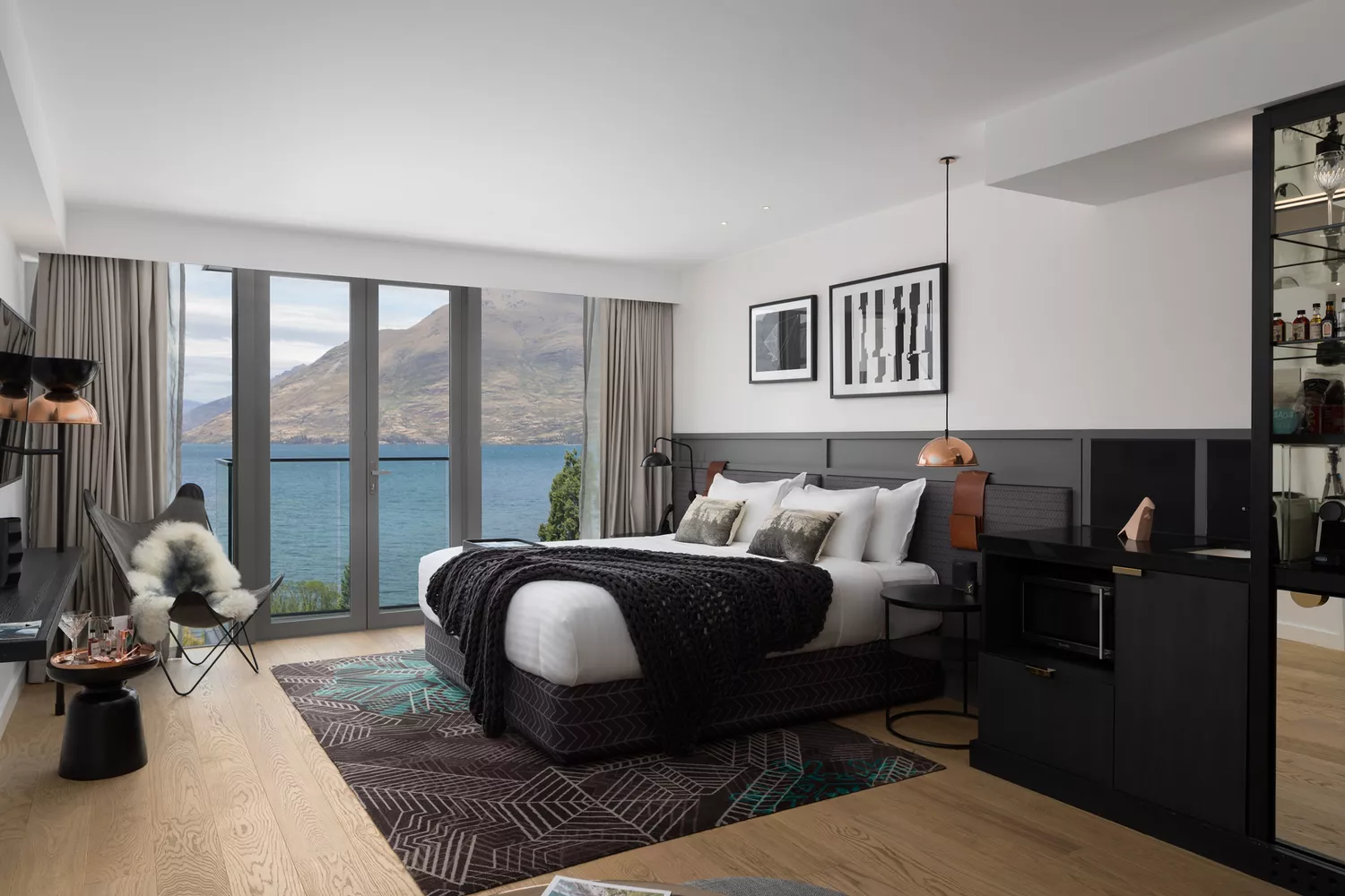 A luxury king bedroom at QT Queenstown with contemporary decor and mountain views