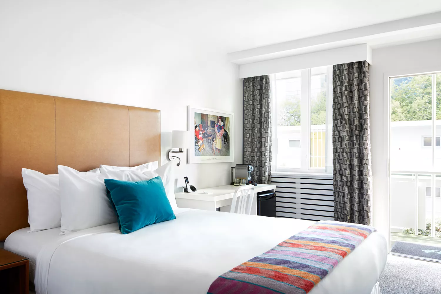 Retro-style guest room at The Burrard with bright color accents and mid-century furniture.