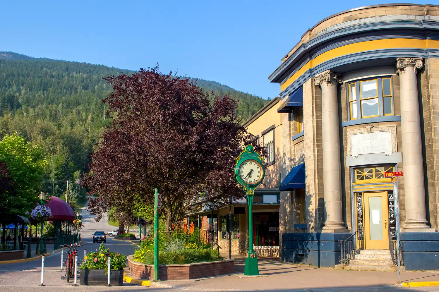 A historic brick building and a prominent street clock on Mackenzie Street in downtown Revelstoke.
