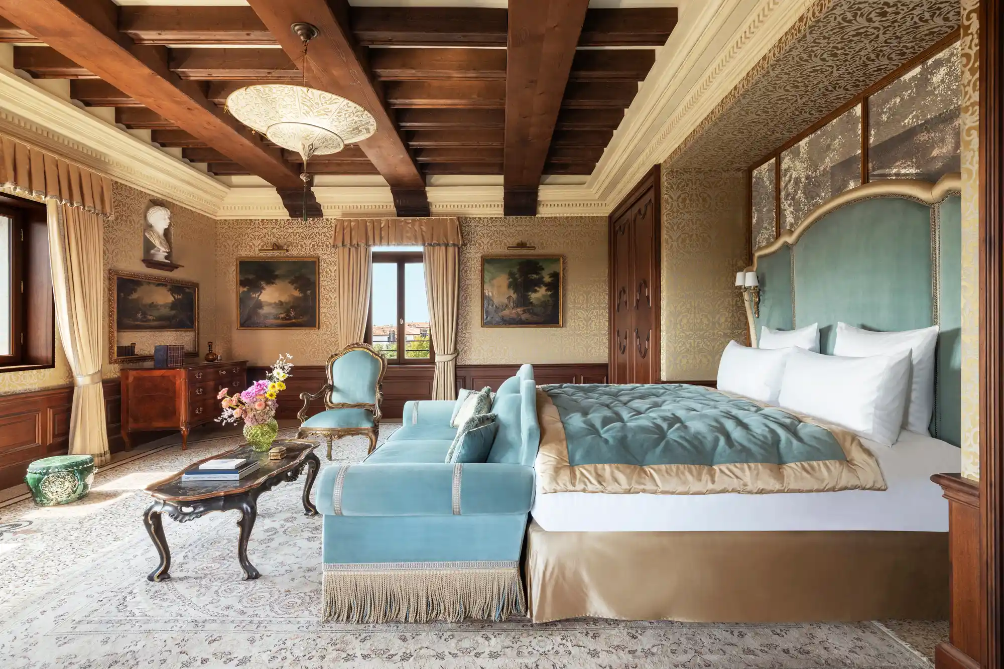 A luxurious bedroom at Airelles Palladio Venice with detailed ceiling frescoes and rich textiles.