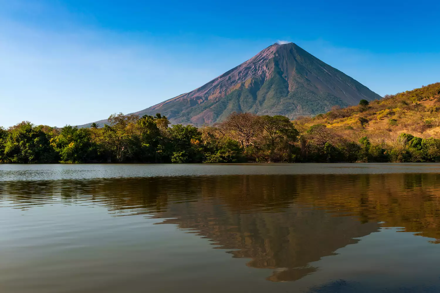The symmetrical cone of Concepcion Volcano reflecting perfectly on the still surface of Lake Nicaragua.