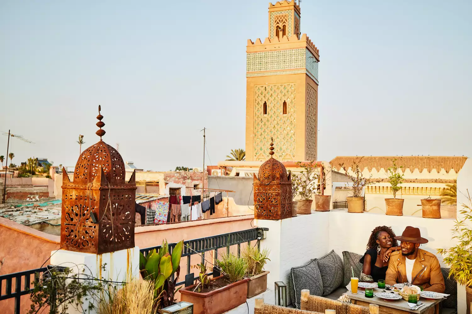 A couple dining on a terrace overlooking the historic rooftops of Marrakesh.