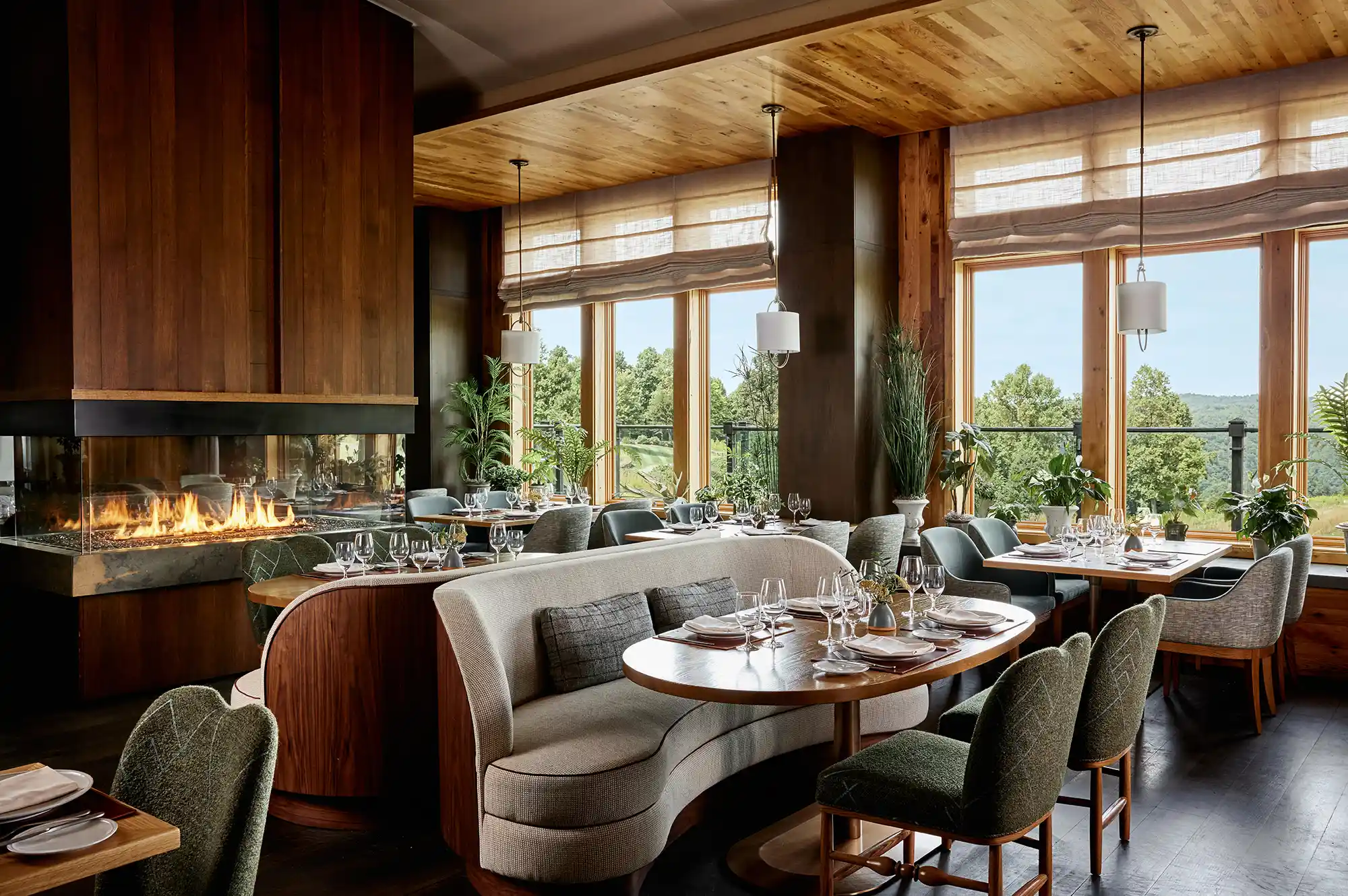 A cozy dining room with a fireplace and large windows overlooking the mountains.