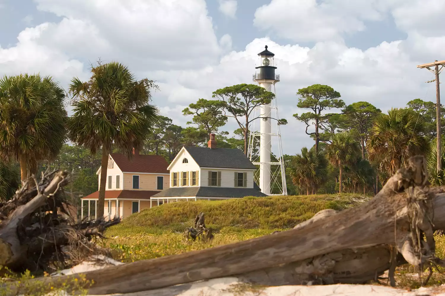The iconic white structure of the Cape San Blas Lighthouse standing against a clear sky.