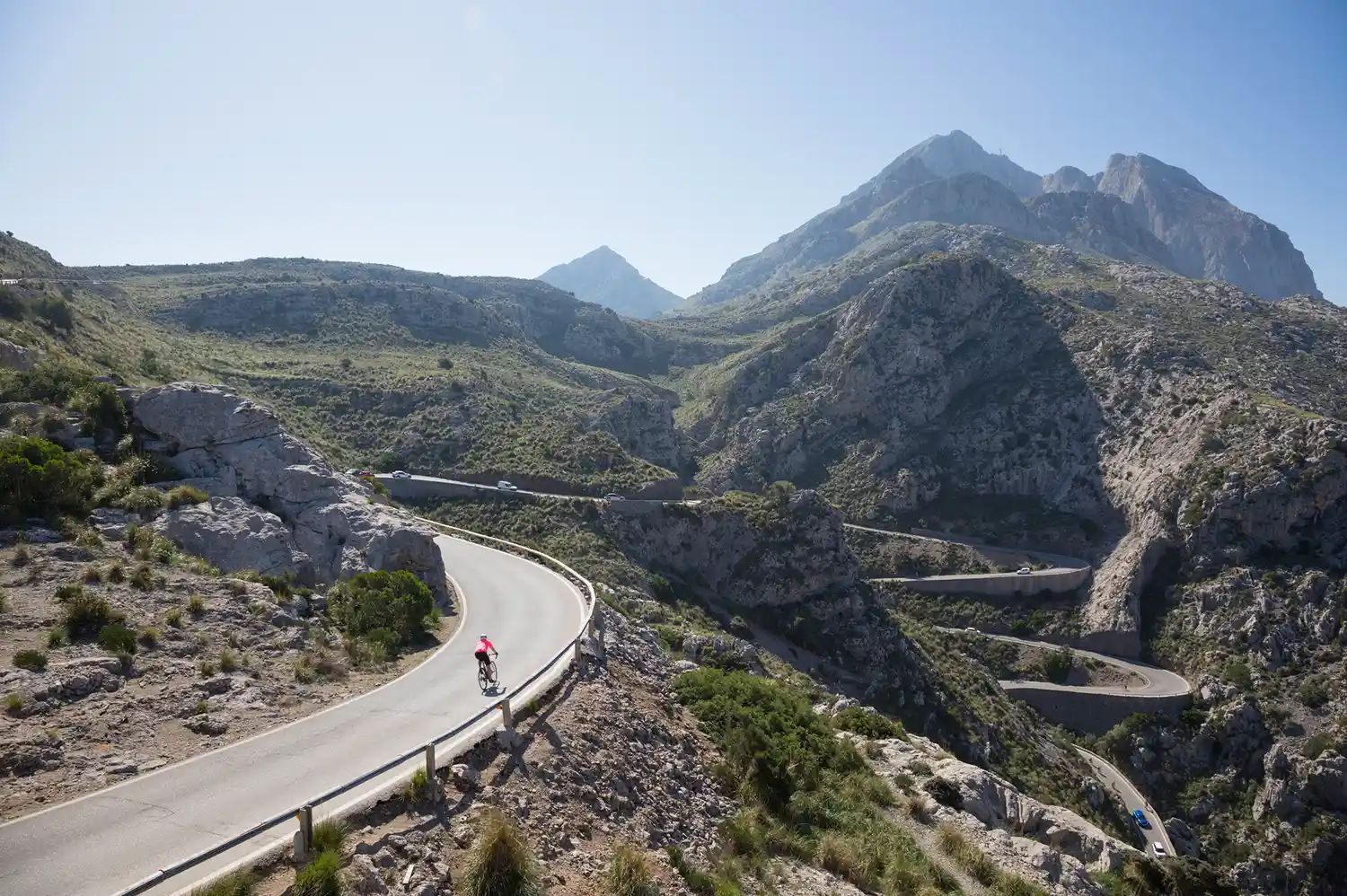 A cyclist navigating the sharp curves of the Sa Calobra pass in Mallorca.