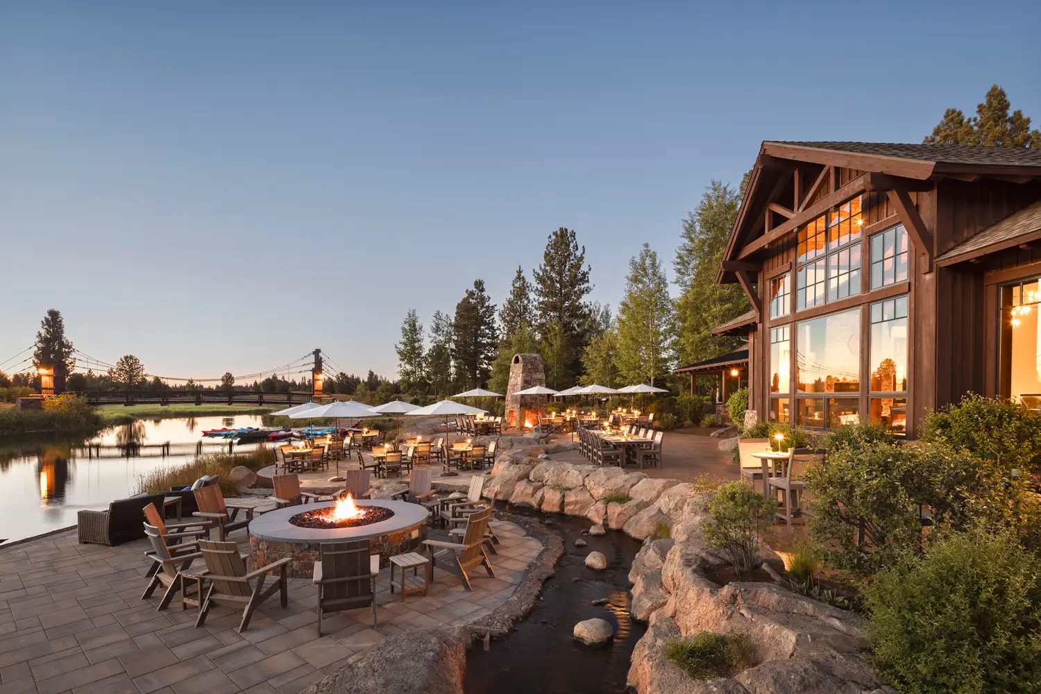 Outdoor patio at Sunriver Resort featuring a communal fire pit and views of the surrounding nature.