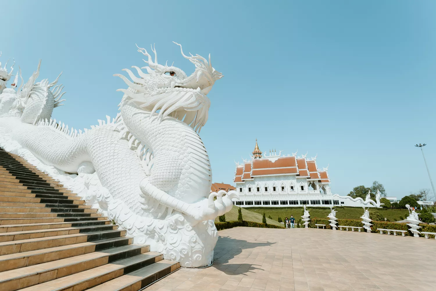 The ornate white dragon sculpture and architecture of the White Temple in Chiang Rai.
