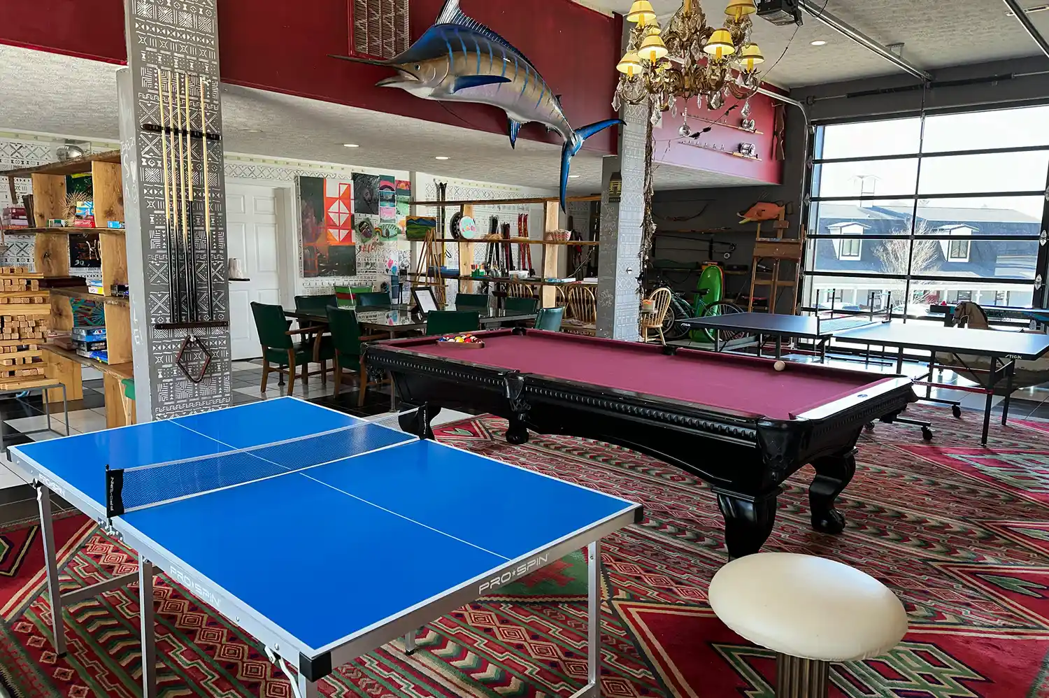 A spacious game room at The Farmhouse containing a table tennis table and a pool table.