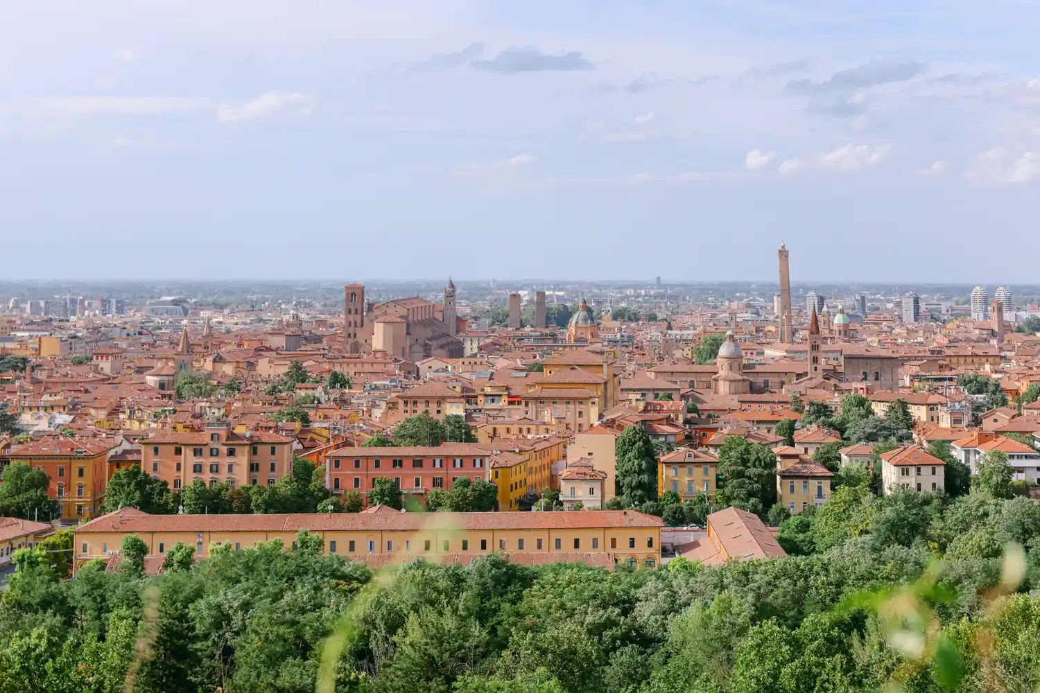 Panoramic view of Bologna's historic center with terracotta rooftops and the Asinelli Tower.