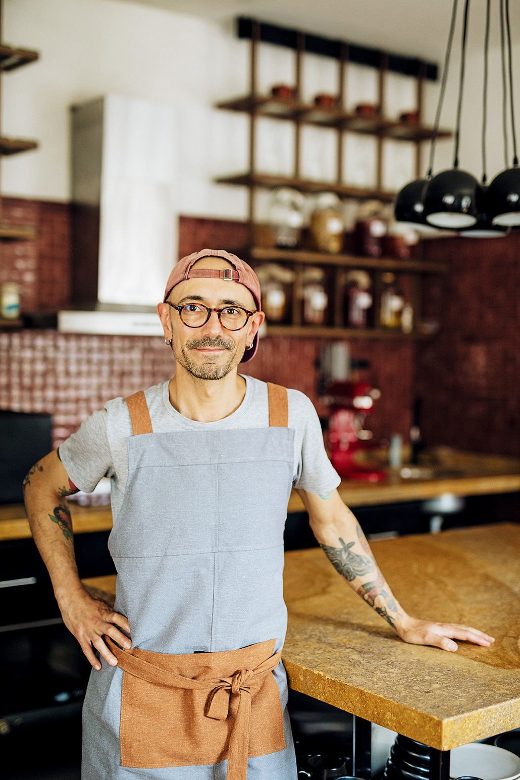 Chef Carlos Basualdo in a professional kitchen focused on the meticulous preparation of a gourmet dish.