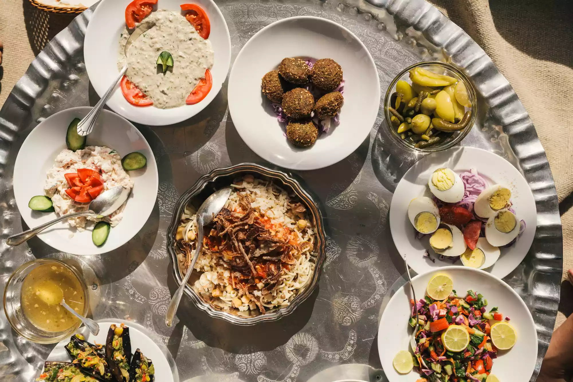Assorted traditional Egyptian mezzes and dishes served on a small round table.