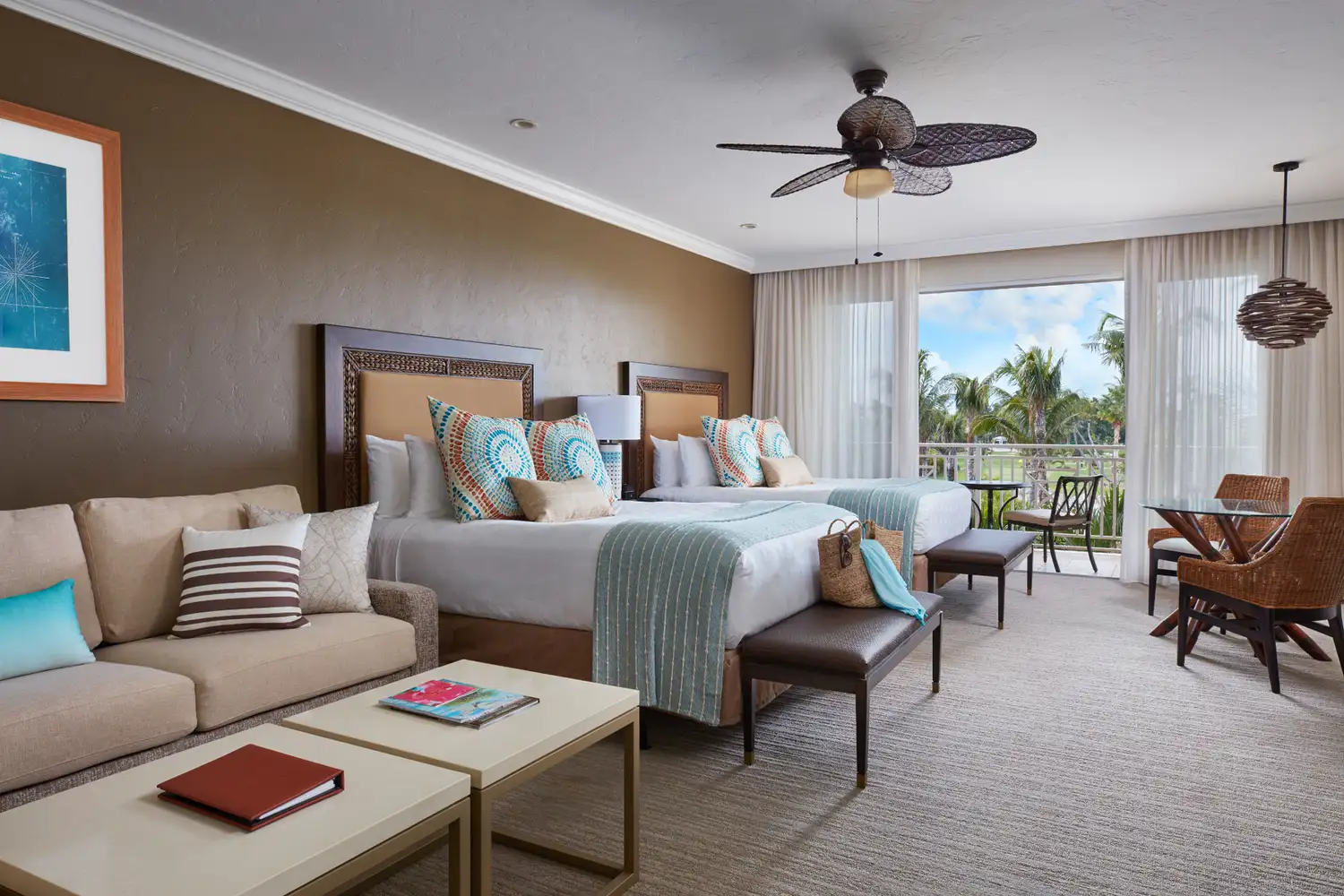 Interior of a luxury guest room at Cheeca Lodge with tropical views through glass doors.
