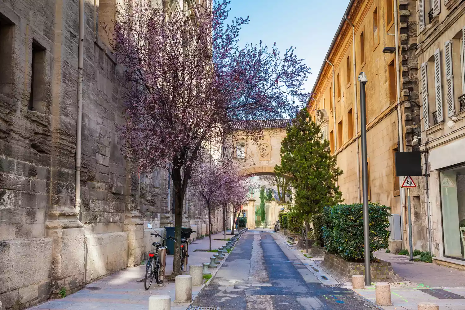 Two bicycles leaning against a stone wall on Rue Frederic Mistral in the old city of Avignon.