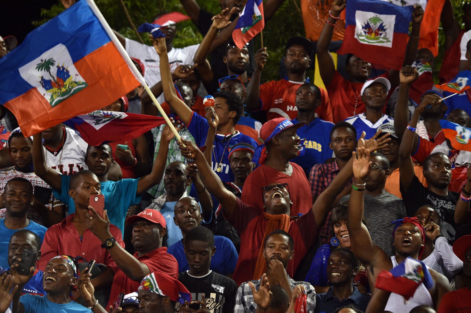 Football players and fans celebrating a significant victory on the pitch.