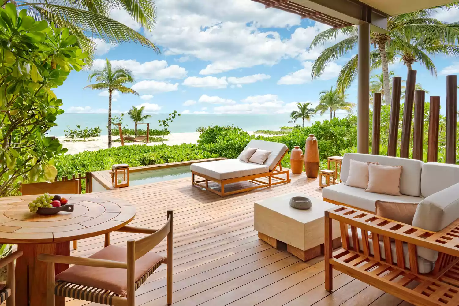 A private wooden patio at Rosewood Mayakoba surrounded by lush tropical greenery and a tranquil waterway.