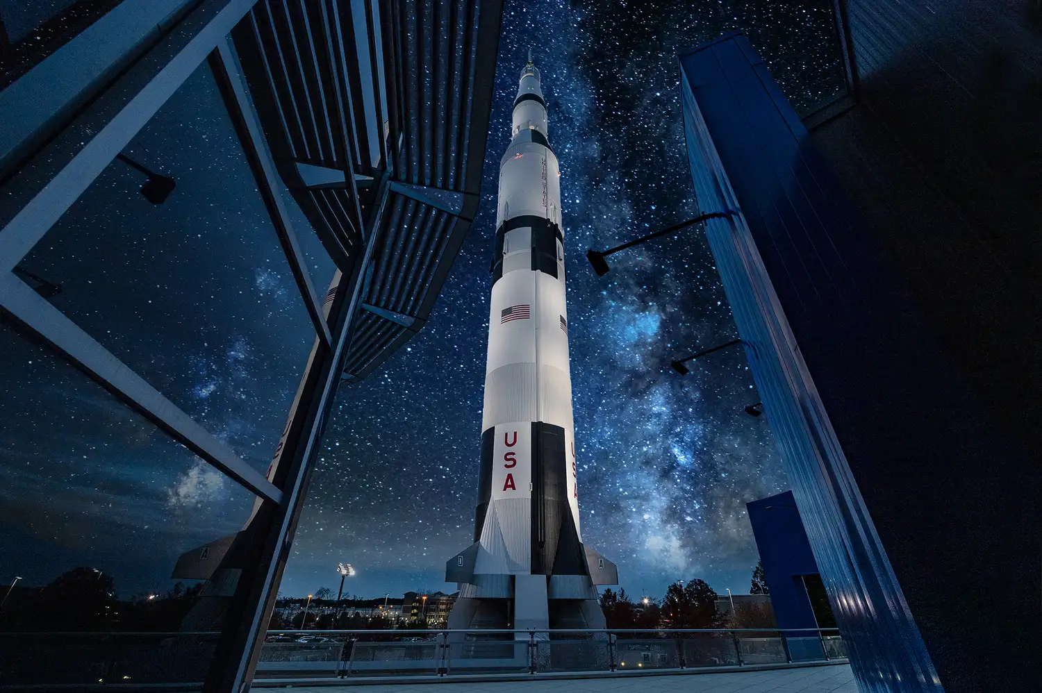 Saturn V rocket replica standing tall under a night sky at the US Space and Rocket Center in Huntsville.