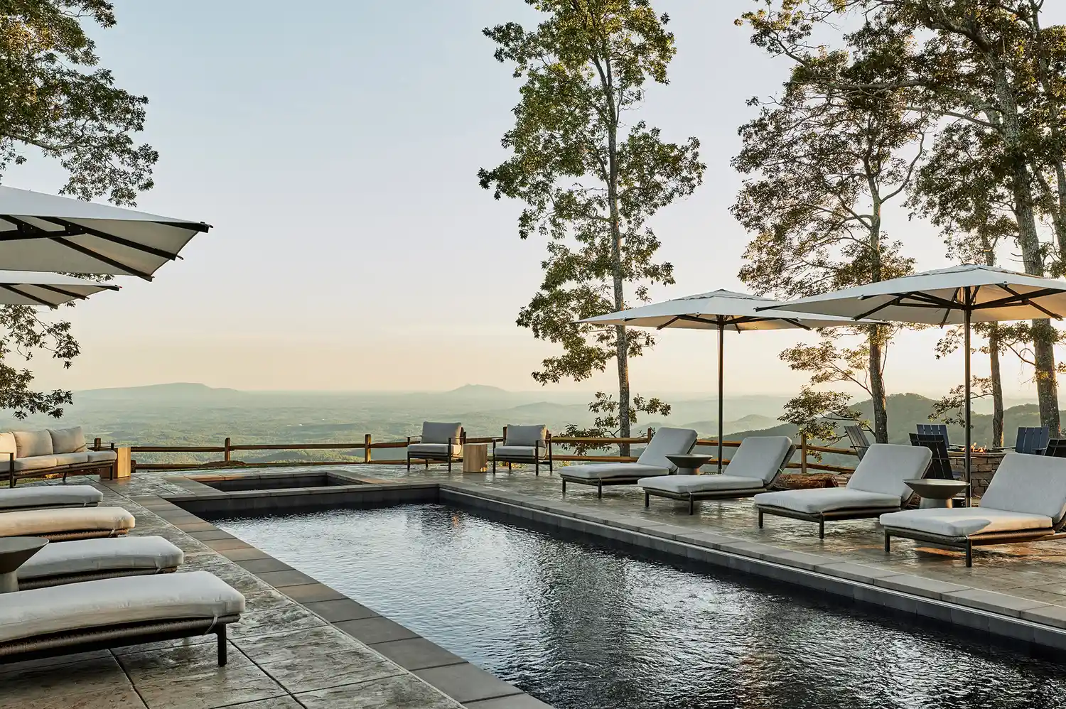 Private heated infinity pool surrounded by trees overlooking a mountain valley.