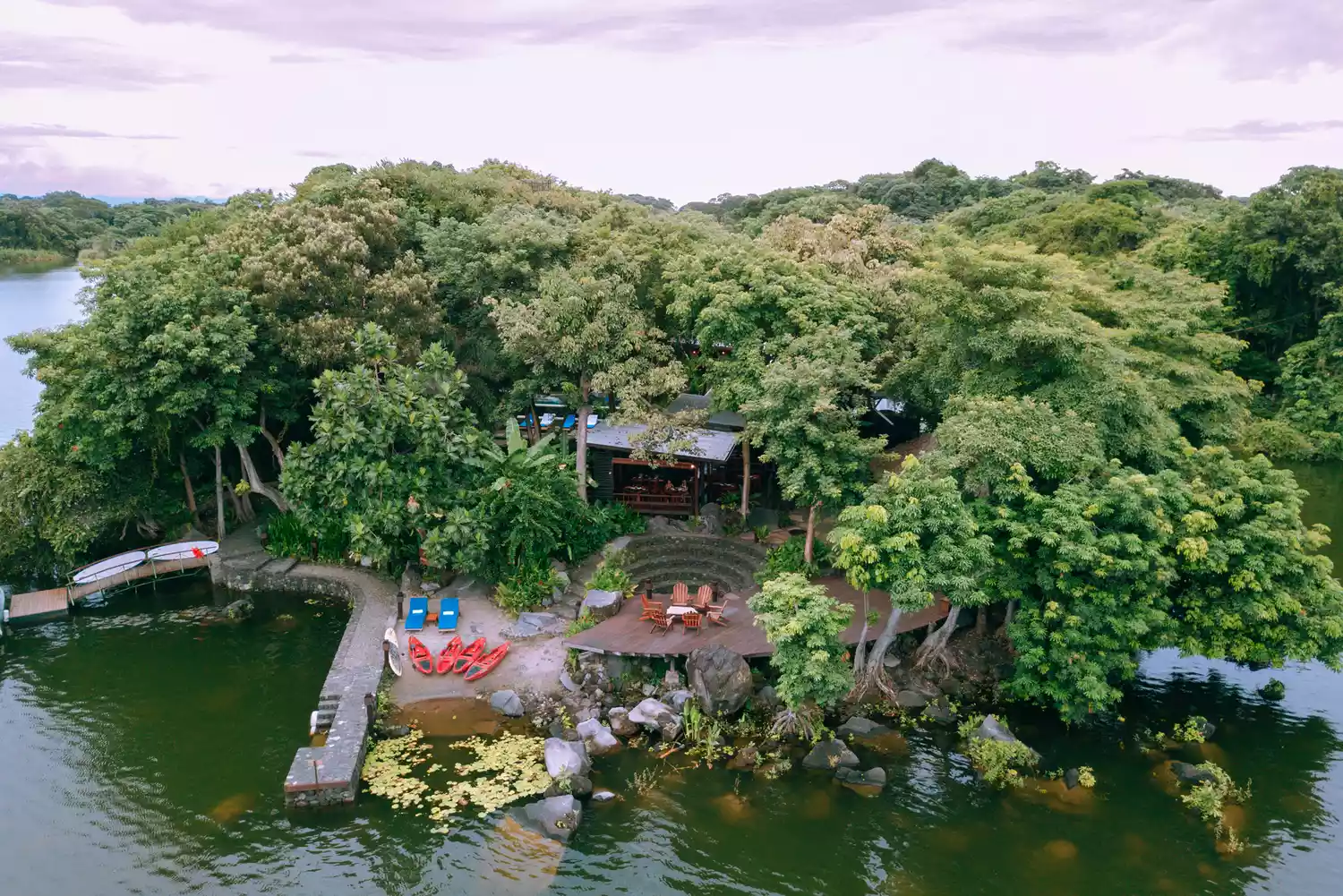 Aerial shot of a luxury boutique lodge situated on a private island surrounded by calm lake waters.