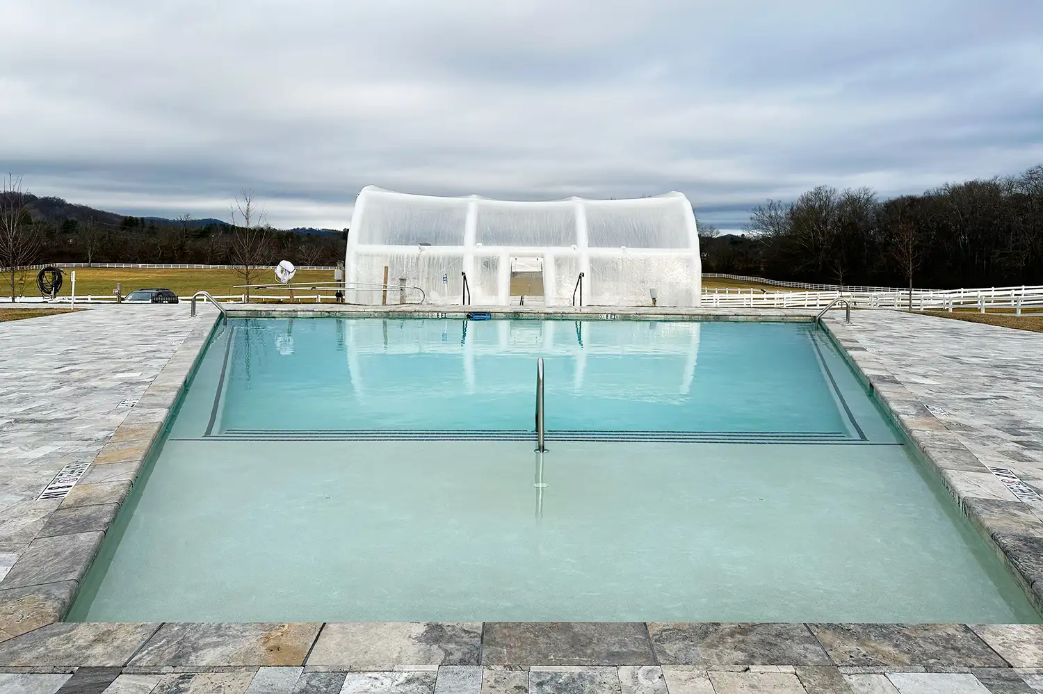 A saltwater swimming pool overlooking the grassy landscape and the dome of Mount Pisgah in North Carolina.
