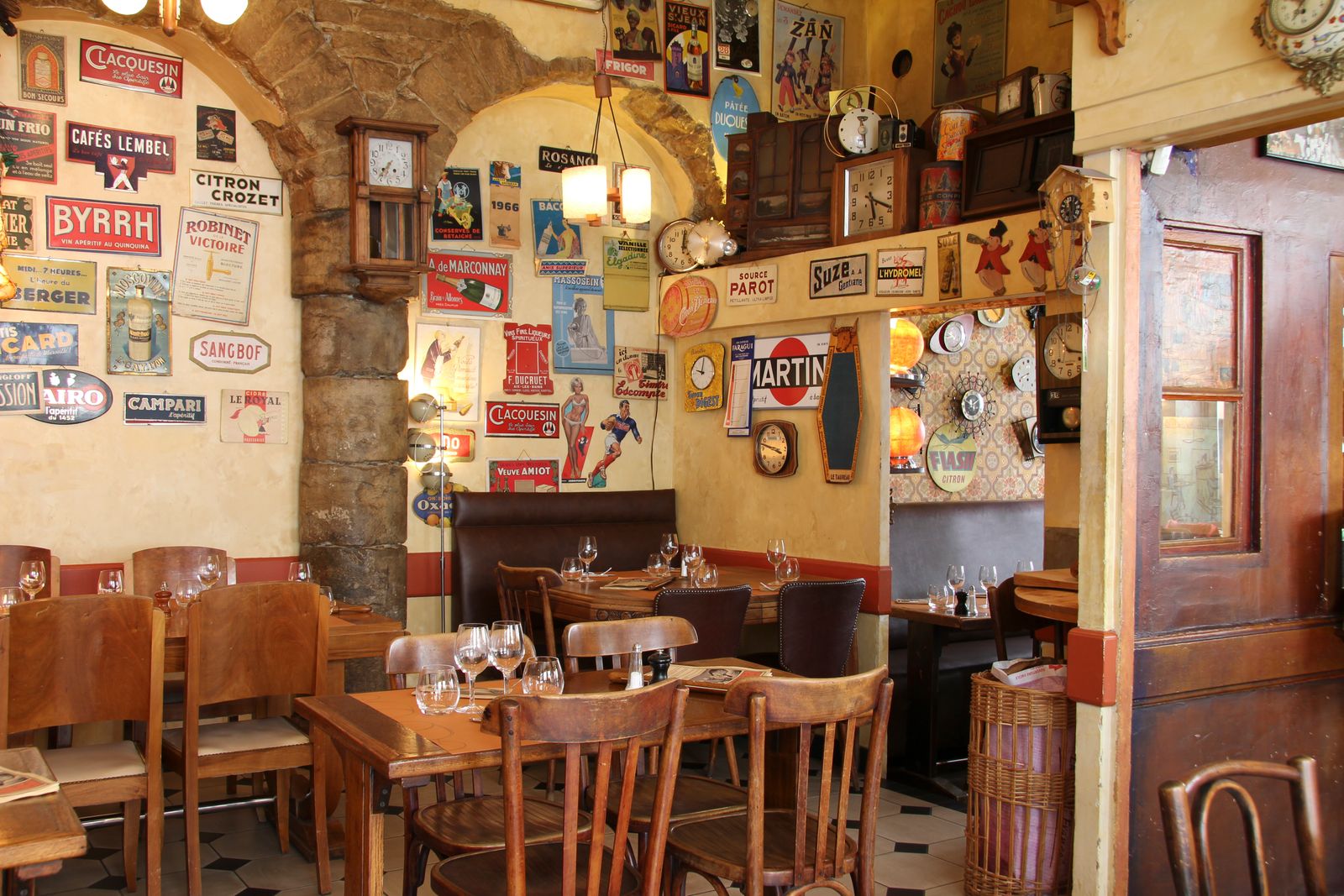 Interior view of a traditional Lyon bouchon with classic wooden furniture and a warm dining atmosphere.