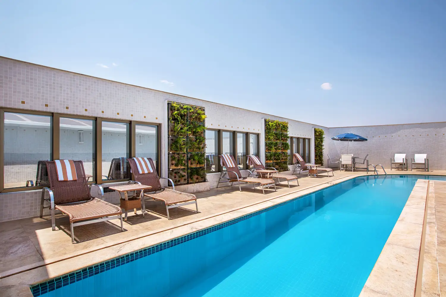 A rooftop swimming pool with lounge chairs at the Meliá Brasil 21 hotel.