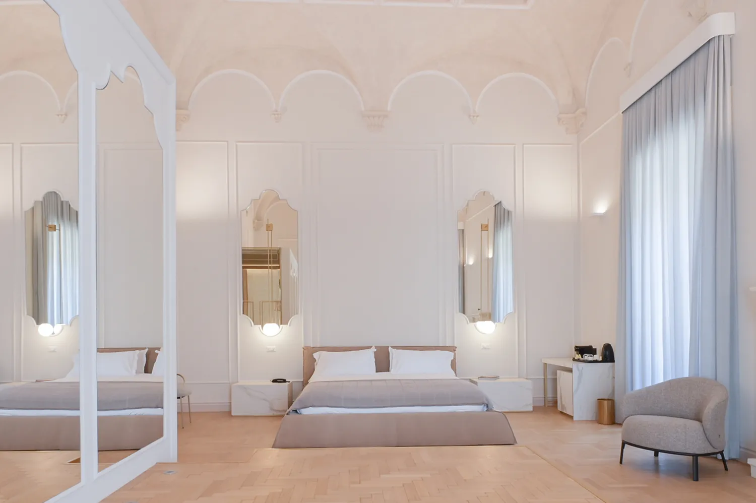 A high-ceilinged noble suite in Palazzo Zimara with elegant furnishings and historic stone walls.