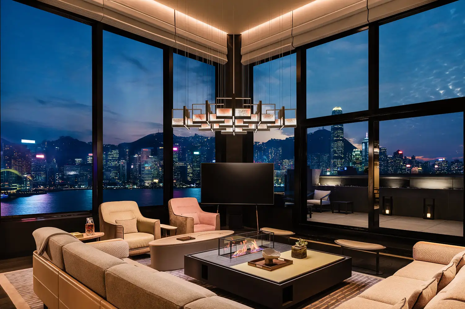 Luxurious living room with large windows showing a city skyline at night, featuring modern furniture at the Regent Hong Kong.