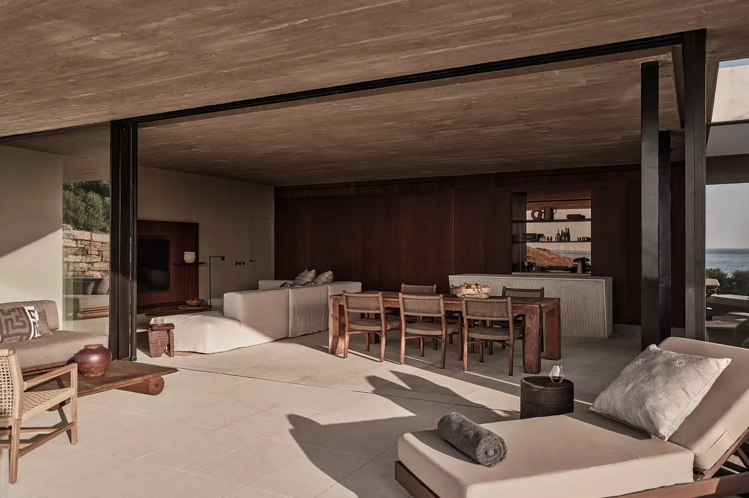 Open-plan living and dining area of a villa at Oku Andalusia with minimalist wooden furniture.