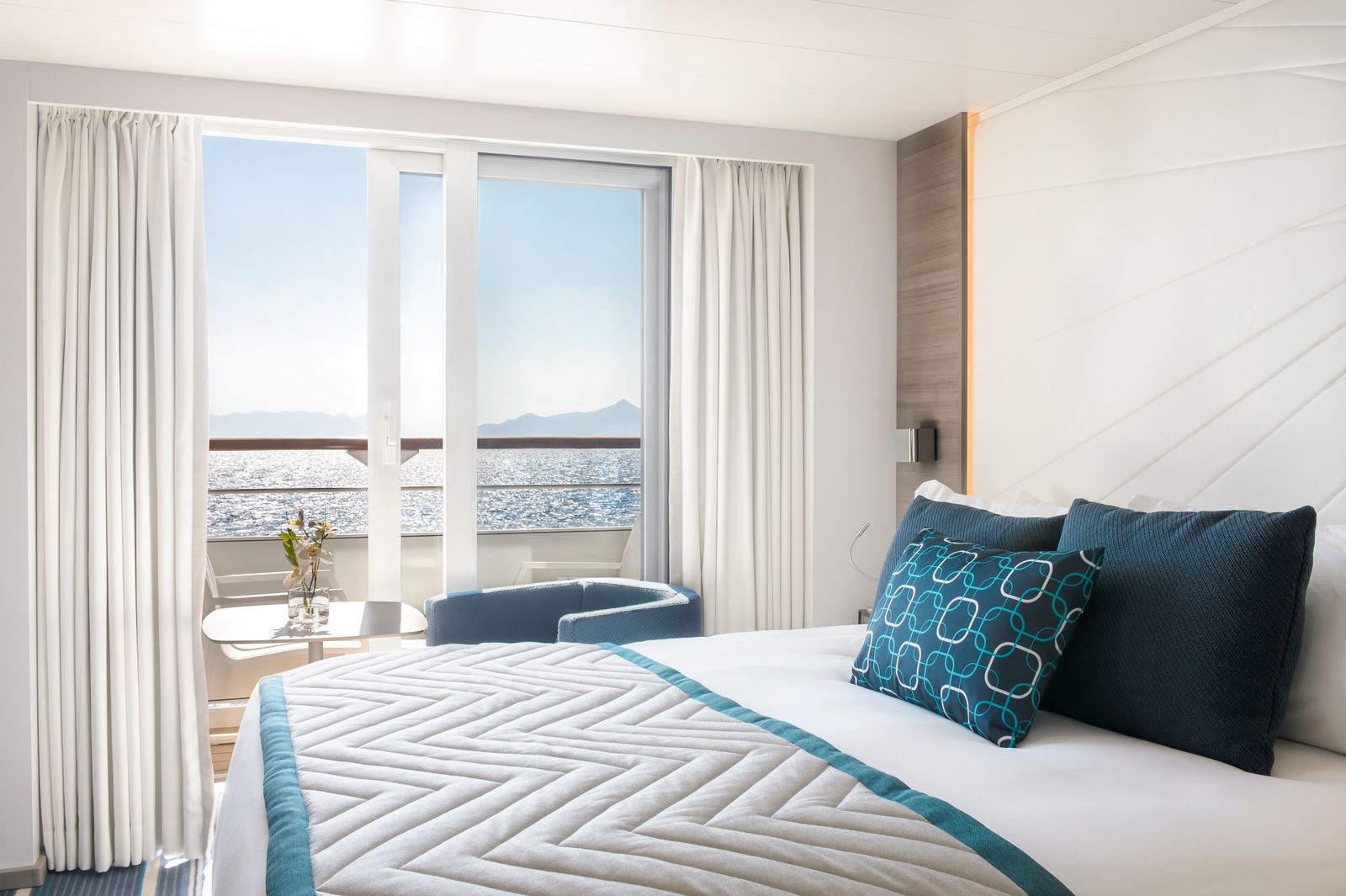 A cozy, well-designed modern ship cabin or hotel room with soft lighting and comfortable bedding.