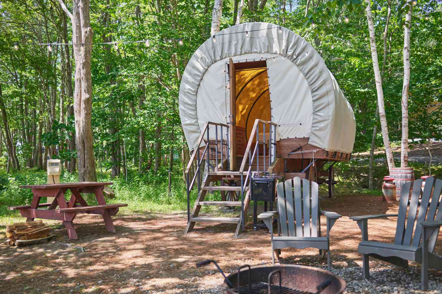 Exterior view of a luxury covered wagon rental surrounded by greenery.