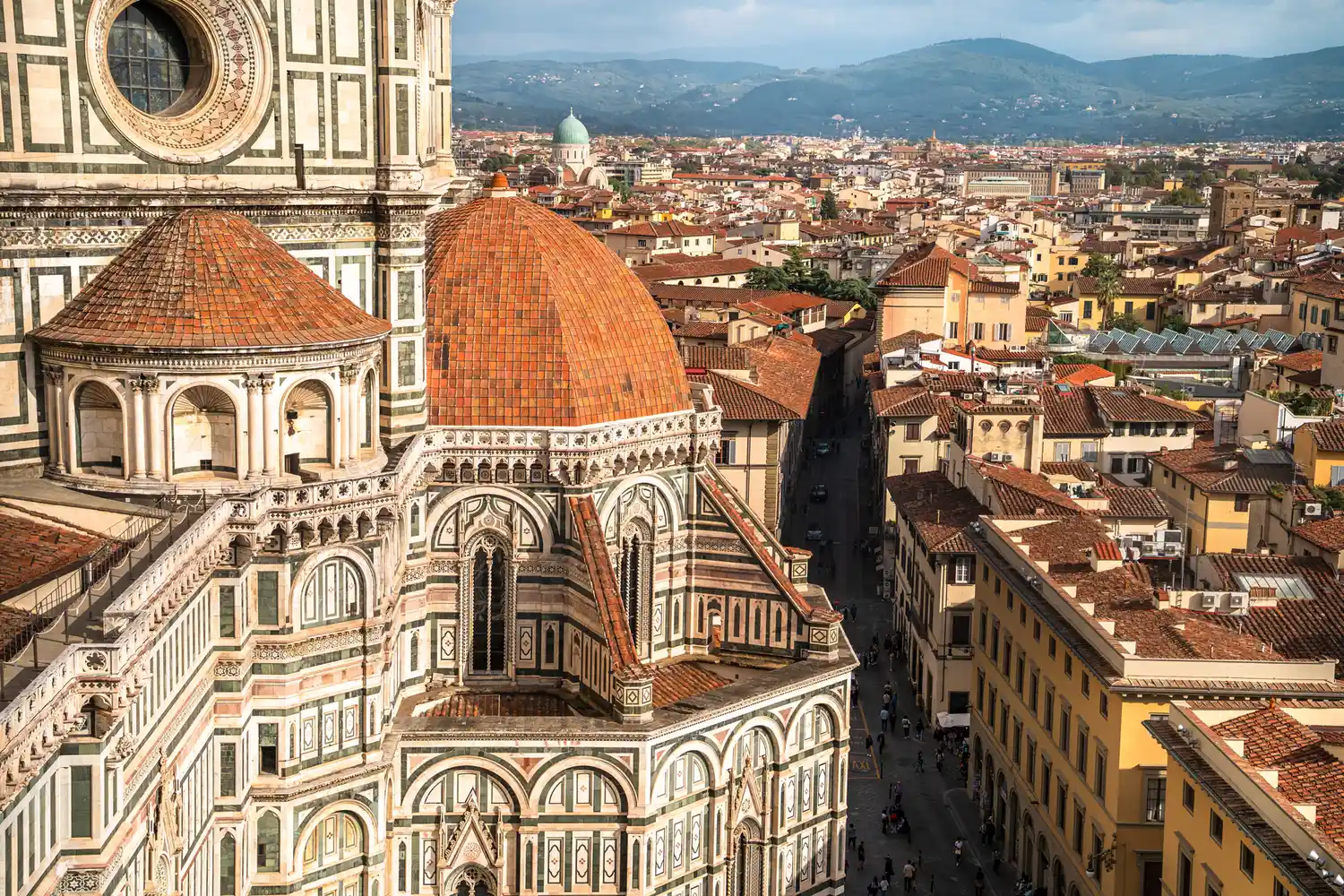 Florence Cathedral dome with cityscape view and hills in background.