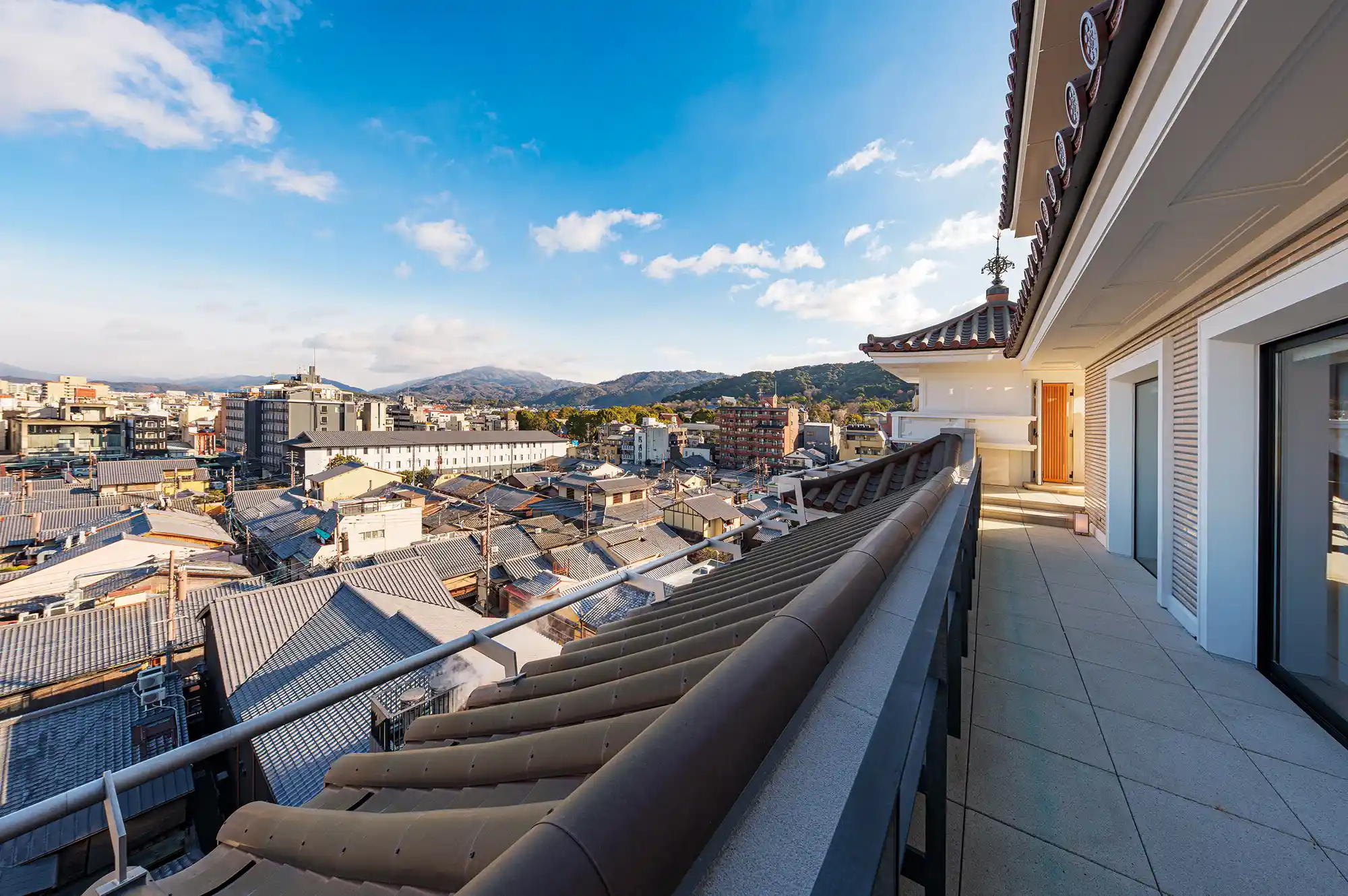 A hotel balcony view overlooking the traditional tiled rooftops of Kyoto.